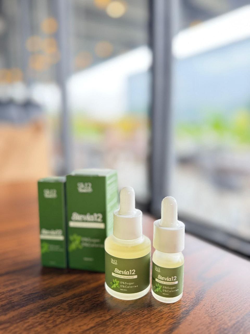 Dua botol Stevia12 SR12 natural sweetener tanpa gula dengan kemasan box hijau di atas meja kayu
